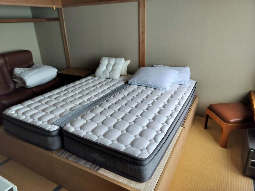 ROOMS Room 303: two single beds side by side on a raised wooden platform over tatami